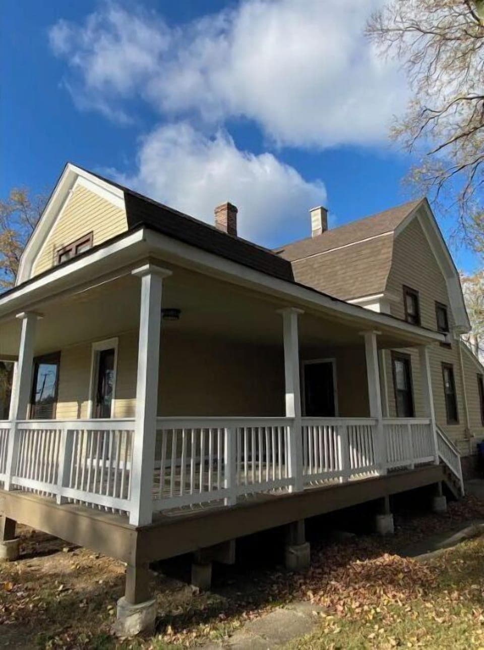 Main house with porch.  Nice wicker furniture on porch, but street is busy.