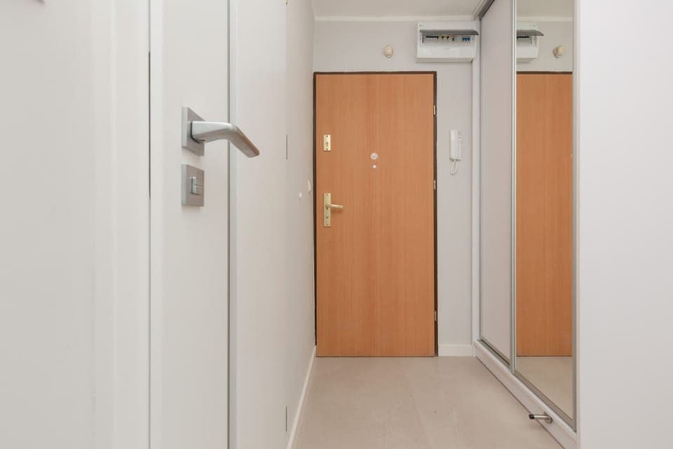 The apartment's entrance hallway with storage cabinets and a clean, well-lit design.
