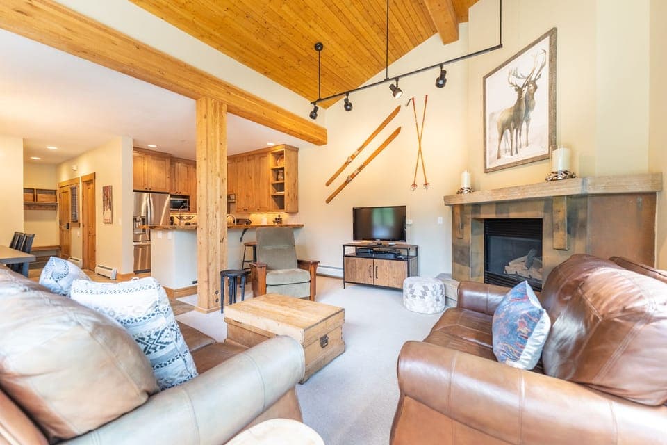 Spacious living area with flat screen TV, gas fireplace, vaulted ceiling and ample seating.