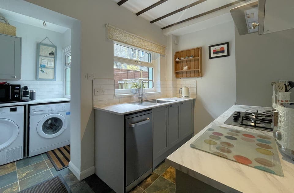 A fully fitted quality kitchen and utility area contains an electric double oven, gas hob, dishwasher, fridge/freezer, microwave, washing machine and tumble-drier.