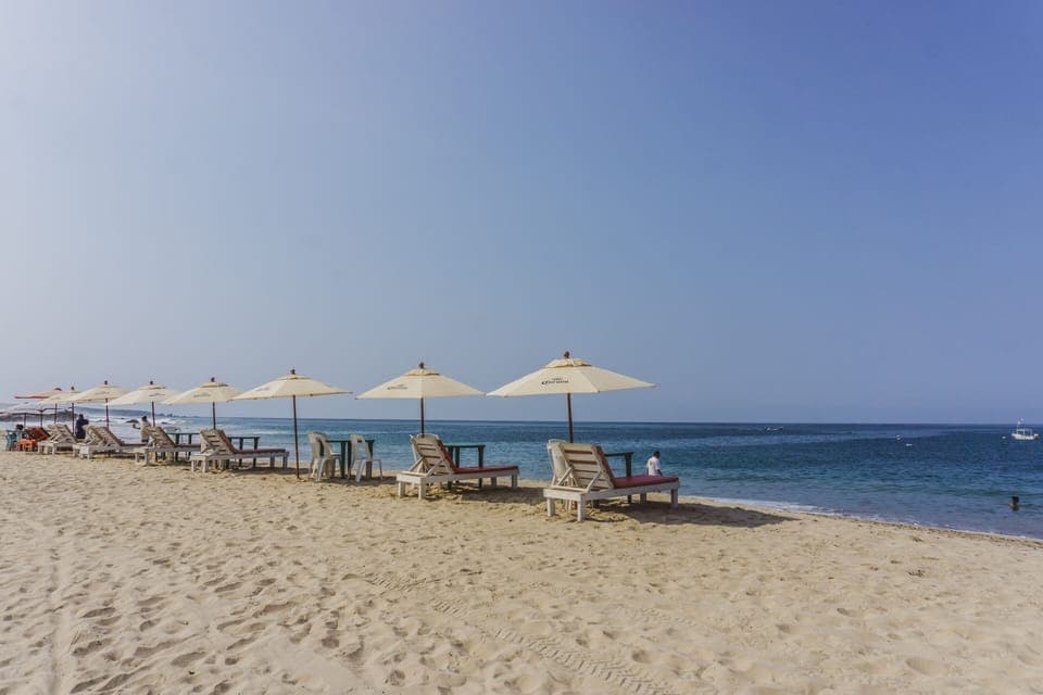 On the beach, white sand, beach umbrellas, beach towels