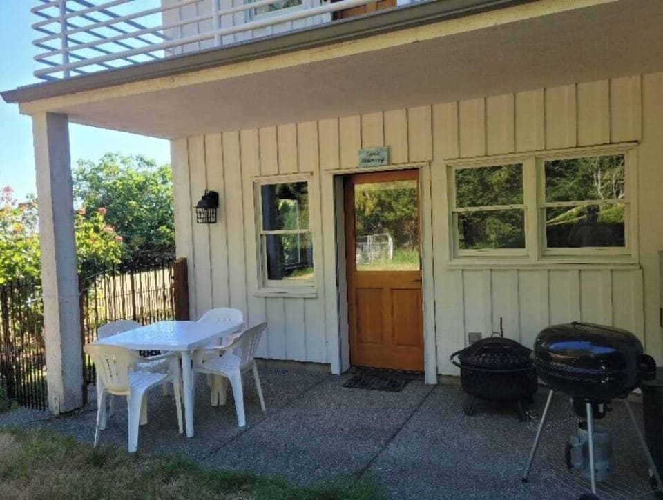 Apartment Entrance below covered deck, with seating area and barbeque