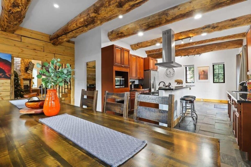The view from the dining area to the nearby kitchen, boasts stainless steel appliances, two separate sinks, a butler’s pantry, and a bar with seats for two.