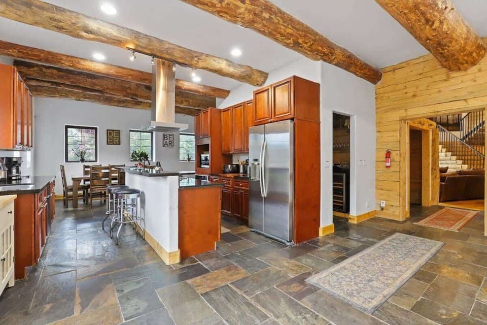 The fabulous kitchen comes complete with stone countertops, stainless steel appliances, two separate sinks, a butler’s pantry, and a bar with seats for two.