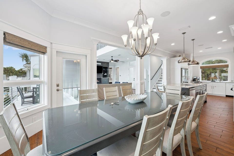 Gather around this elegant glass dining table where memorable meals await beneath the stunning chandelier, with your kitchen just steps away.