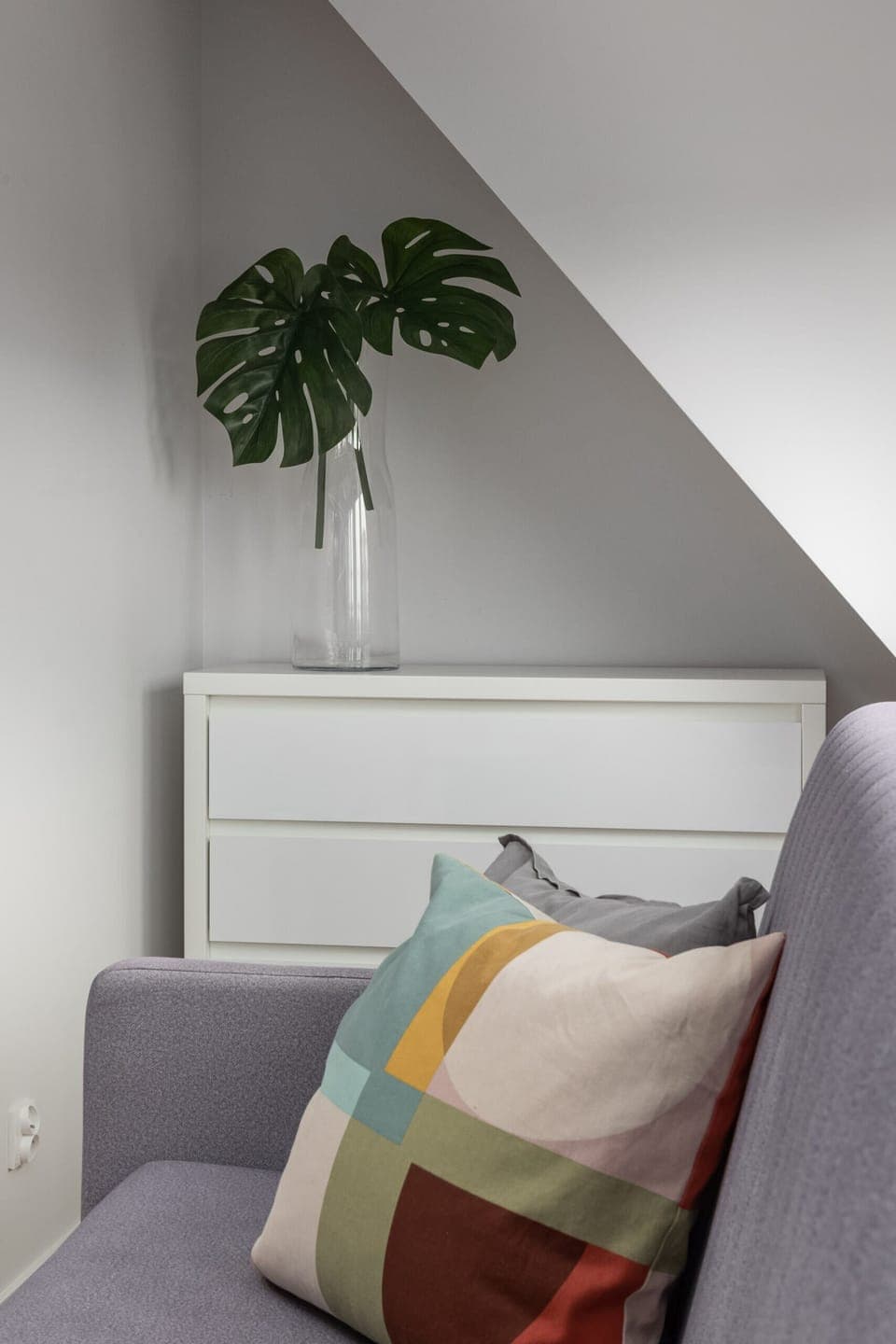 A stylish bedroom with a comfortable bed, colorful pillows, and soft lighting for a peaceful stay.
