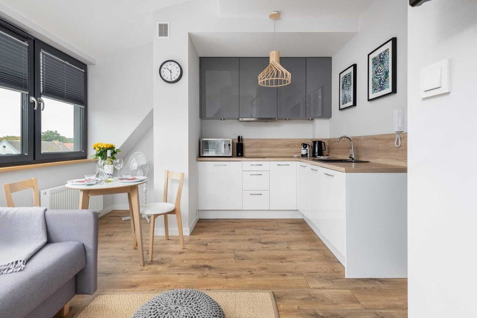 A bright open-plan kitchen and dining space with elegant furnishings and wooden floors.
