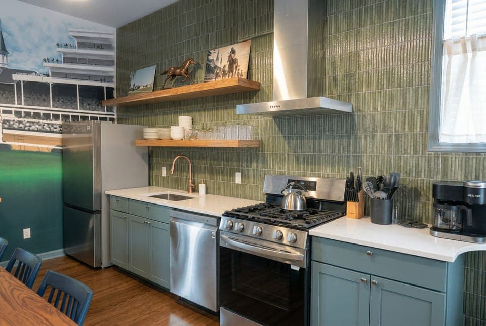 Cook wonderful family meals using the premium stainless steel gas stove and sparkling clean countertops. The gorgeous green tile backsplash and pale blue cabinets give this cooking space so much fresh charm.
