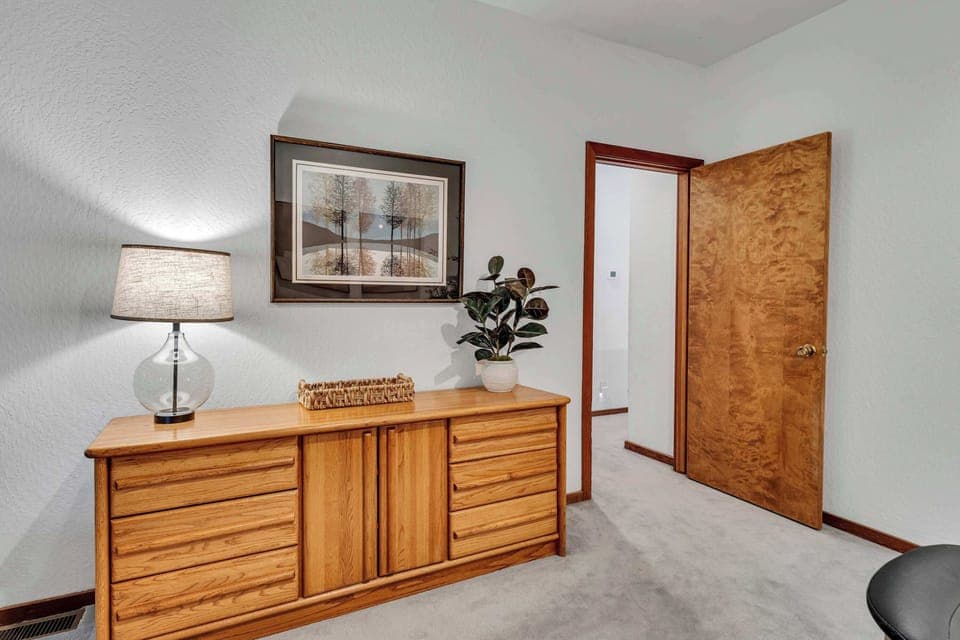 Bedroom 1 (main floor): King bed, TV, dedicated workspace, walk-in closet, forest views