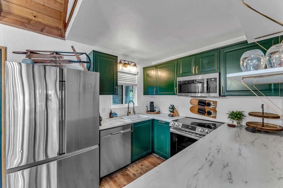 Kitchen: Stainless steel appliances, cooking utensils, kettle, coffee maker, tableware