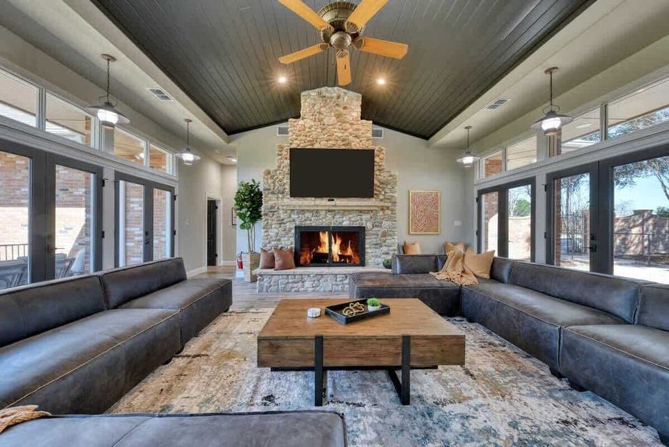 Great room with vaulted ceiling and stone fireplace has direct views of the Guadalupe RIver