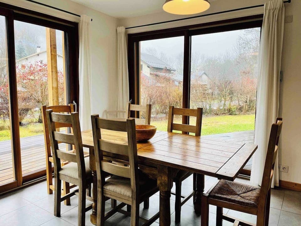 The dining table is in front of patio doors to the pretty garden and terrace
