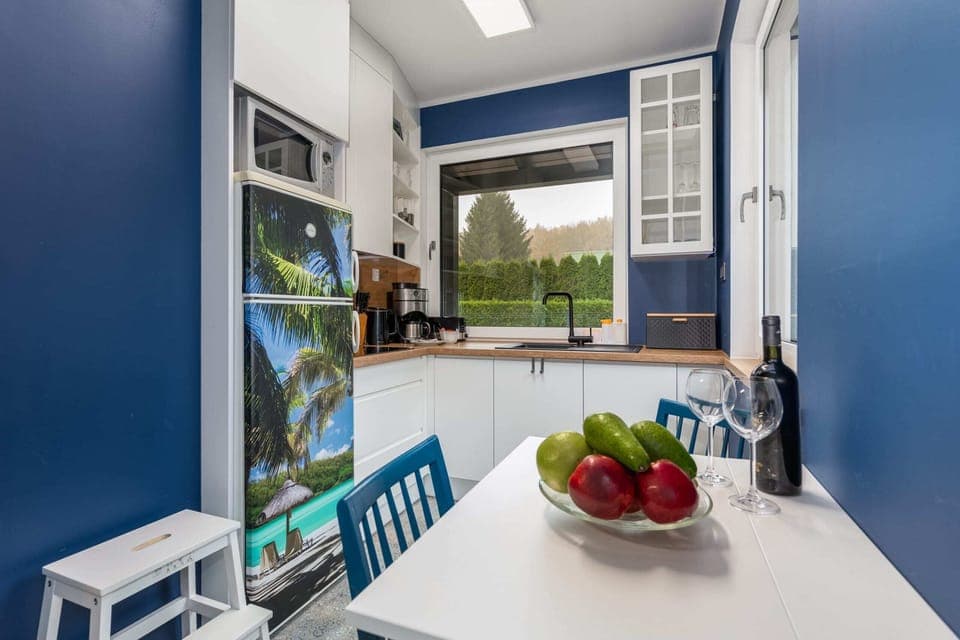Kitchenette with kettle and refrigerator. 