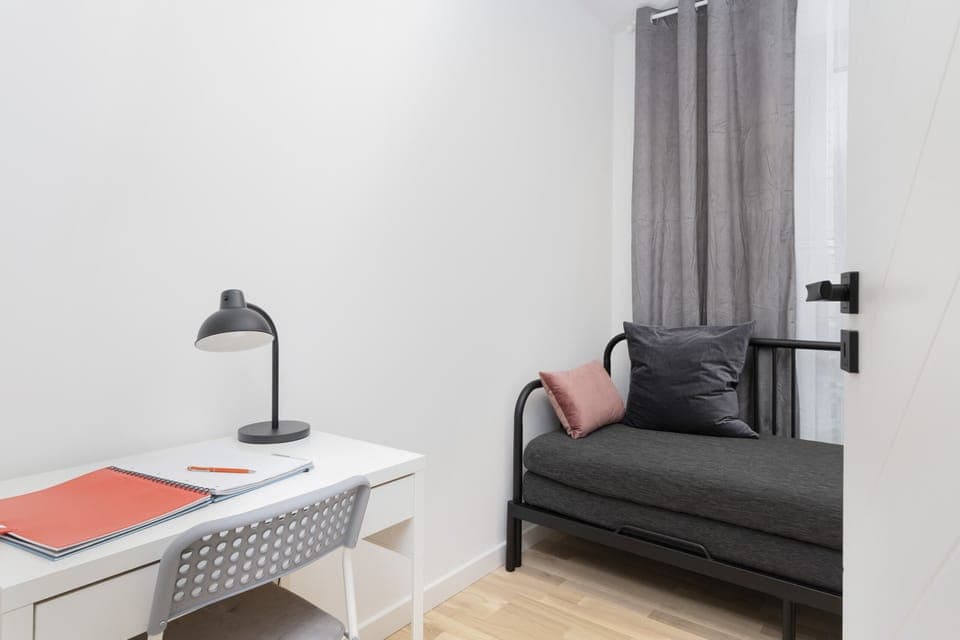  A second bedroom with soft bedding, natural light, and a minimalist design.
