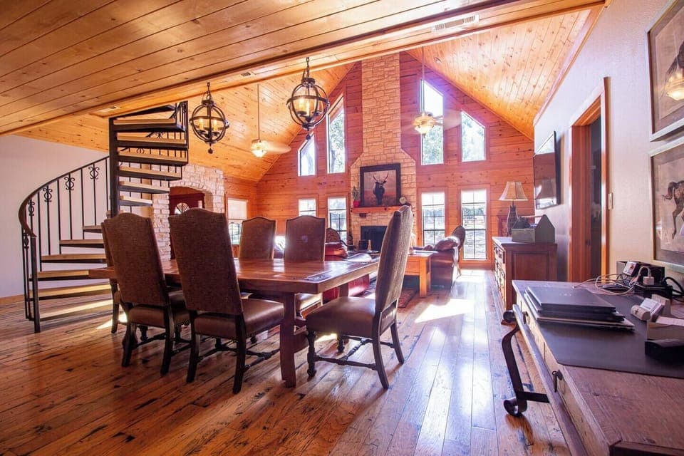 Main Lodge - Dining and Lounge. Gather around the big, beautiful wooden table in the main lodge's dining area, featuring six comfortable chairs—perfect for family meals and creating lasting memories together.
