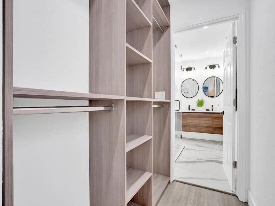 Closet in primary bedroom that leads into a gorgeous en suite bathroom