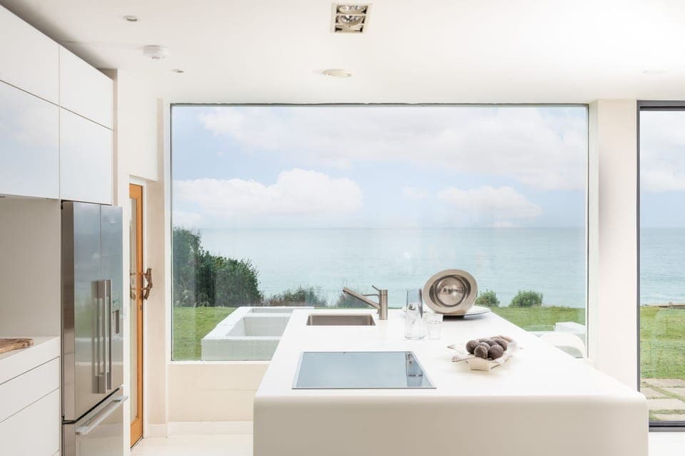 The kitchen with open doors and fridge/freezer - Little Cottage