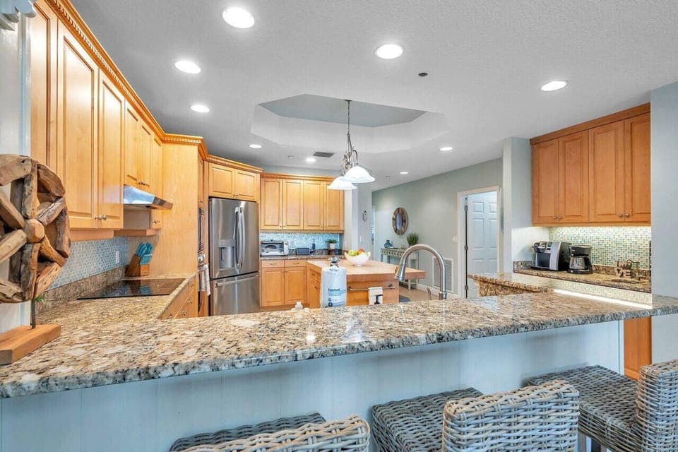 Spacious kitchen island w/ polished granite, perfect for casual meals or prep time.