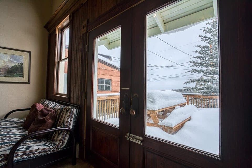 【Winter Views】 Snow through the tall windows — the fireplace earns its keep.