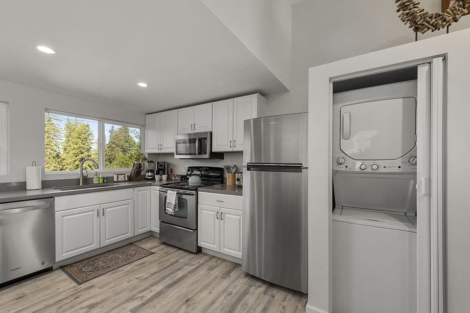 The newly updated kitchen has stainless steel appliances and a laundry closet.