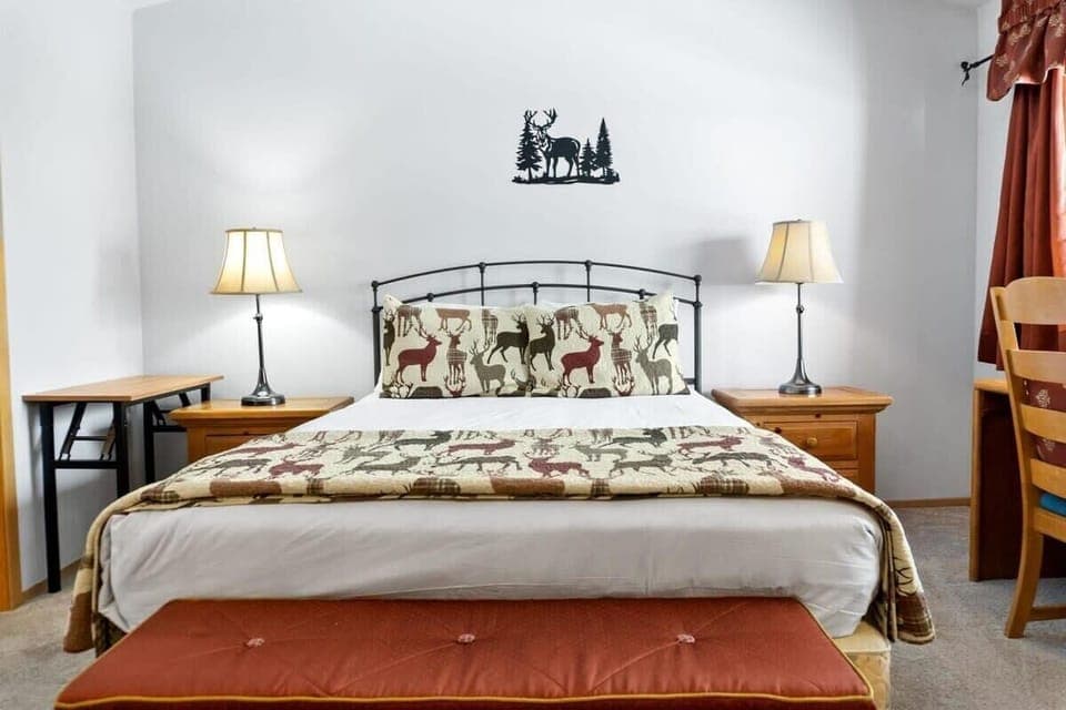 The spacious master bedroom is equipped with everything you need for a comfortable stay with a queen-size bed, a large closet, a workspace, and an attached bathroom.