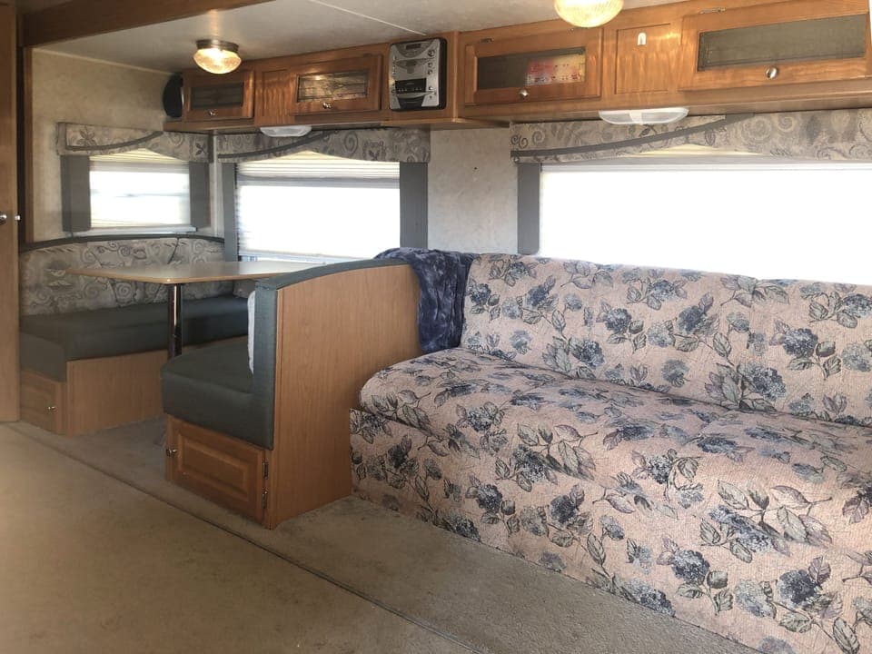 Inside RV, sofa and dining area.