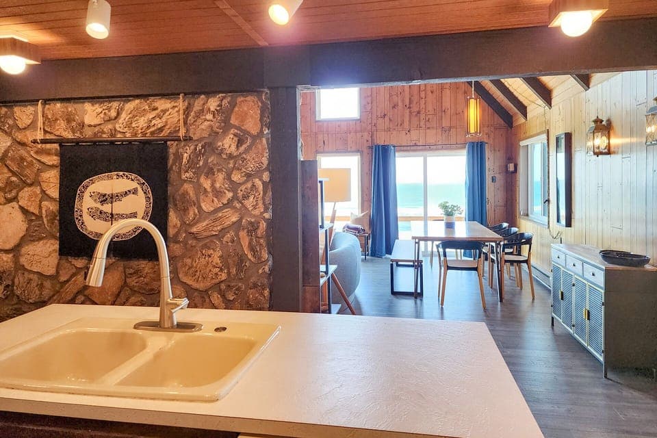 The kitchen is on the other side of the fireplace.