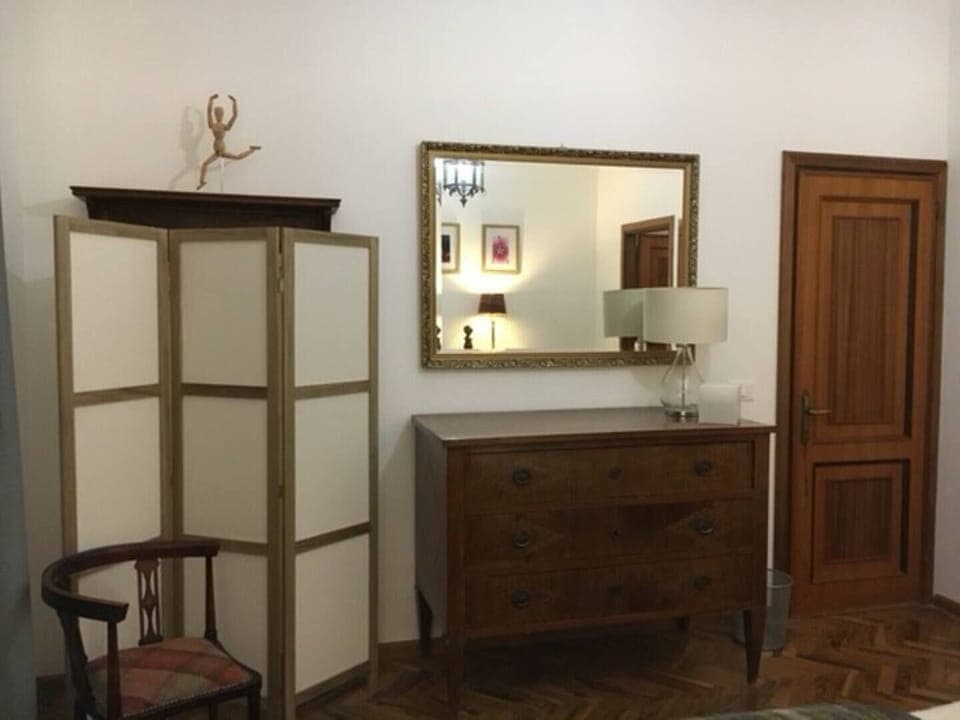 A screened hanging rail is provided with a large chest of drawers.