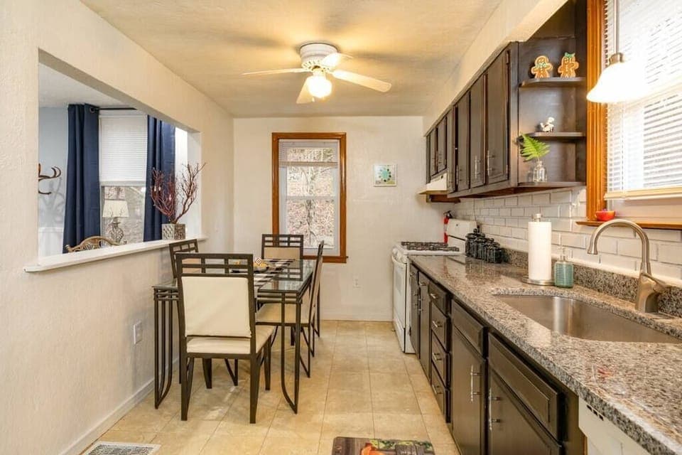 A large galley style kitchen with granite countertops and full table.  Fully stocked with all appliances and cooking supplies