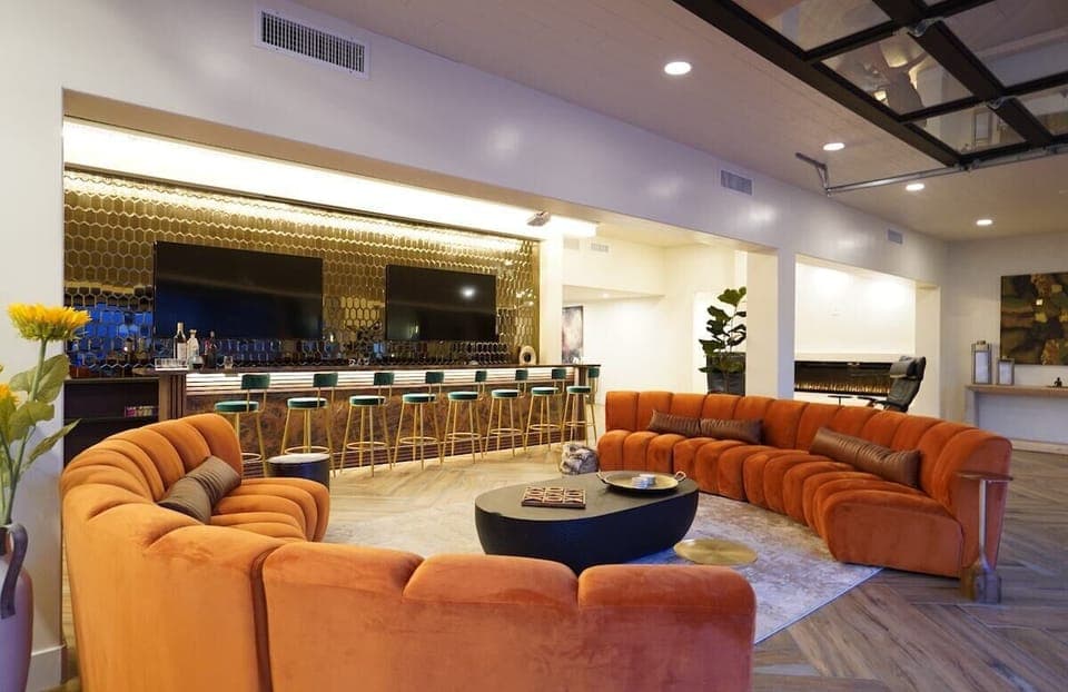 Stylish bar and lounge area with TV's, projector, and custom chandelier 