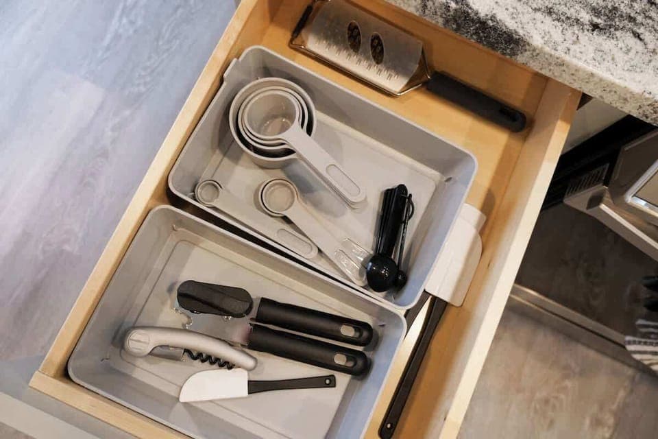 - Organized kitchen drawer with measuring tools   - Wine opener and utensils ready for guest use   - Thoughtful details for cooking convenience  