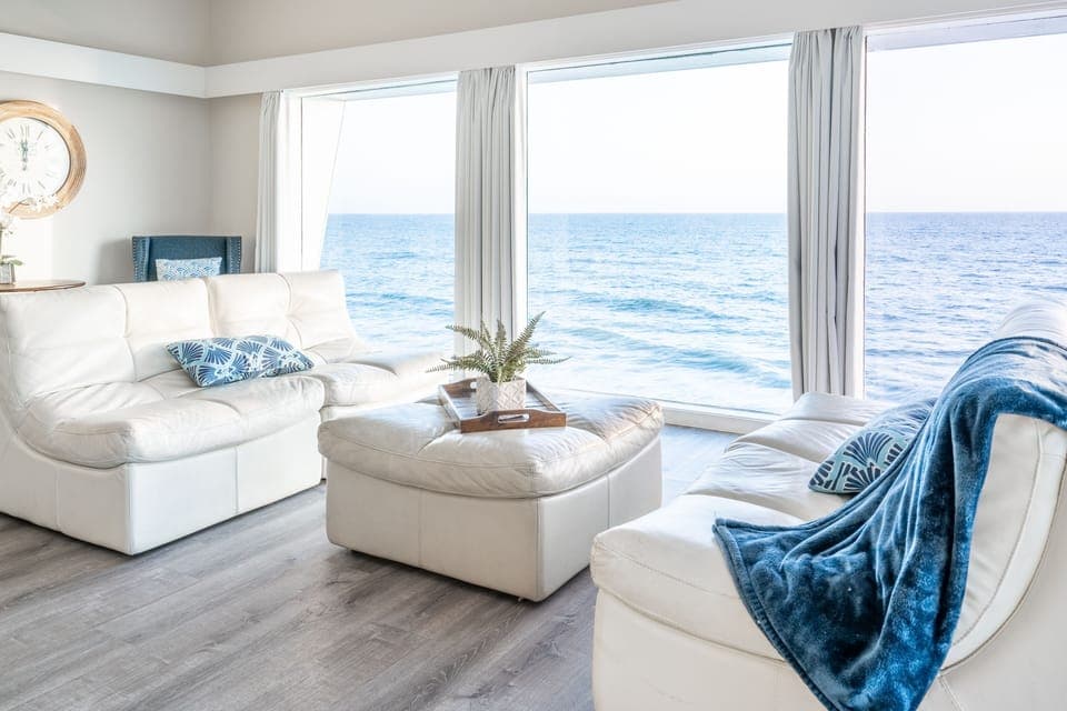 Coastal living room with white leather sofas and sweeping ocean