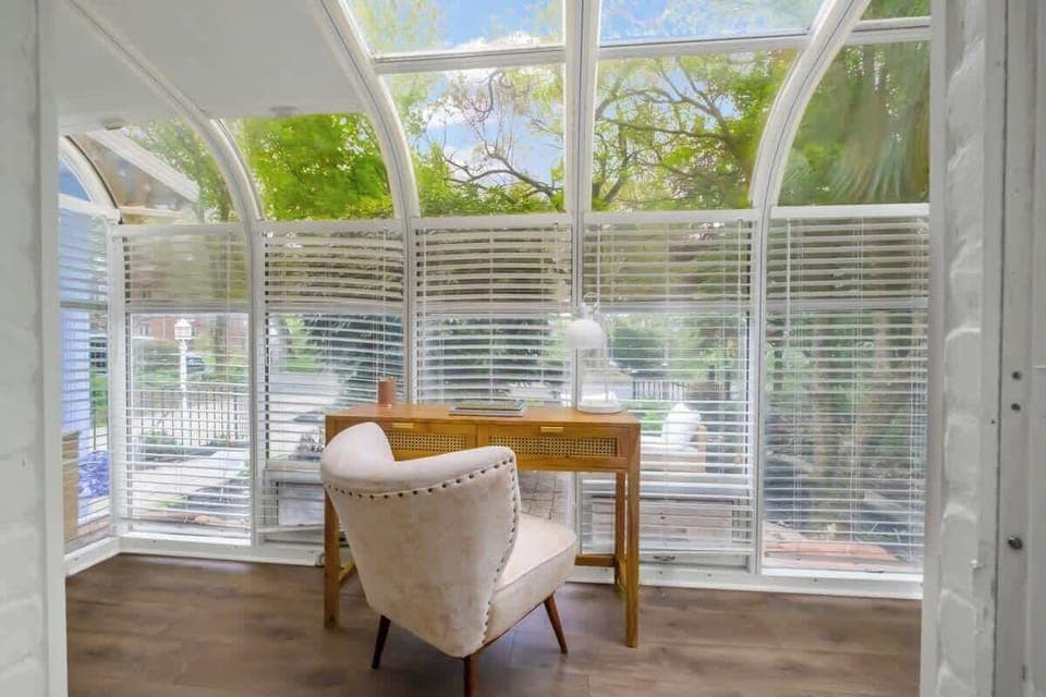 Very comfortable desk and chair in bright sunroom space, over looking the yard.
