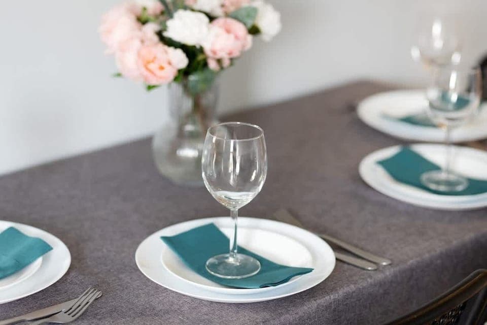 A close-up of the dining table set with elegant plates, glasses, and floral decorations, creating an inviting dining atmosphere.
