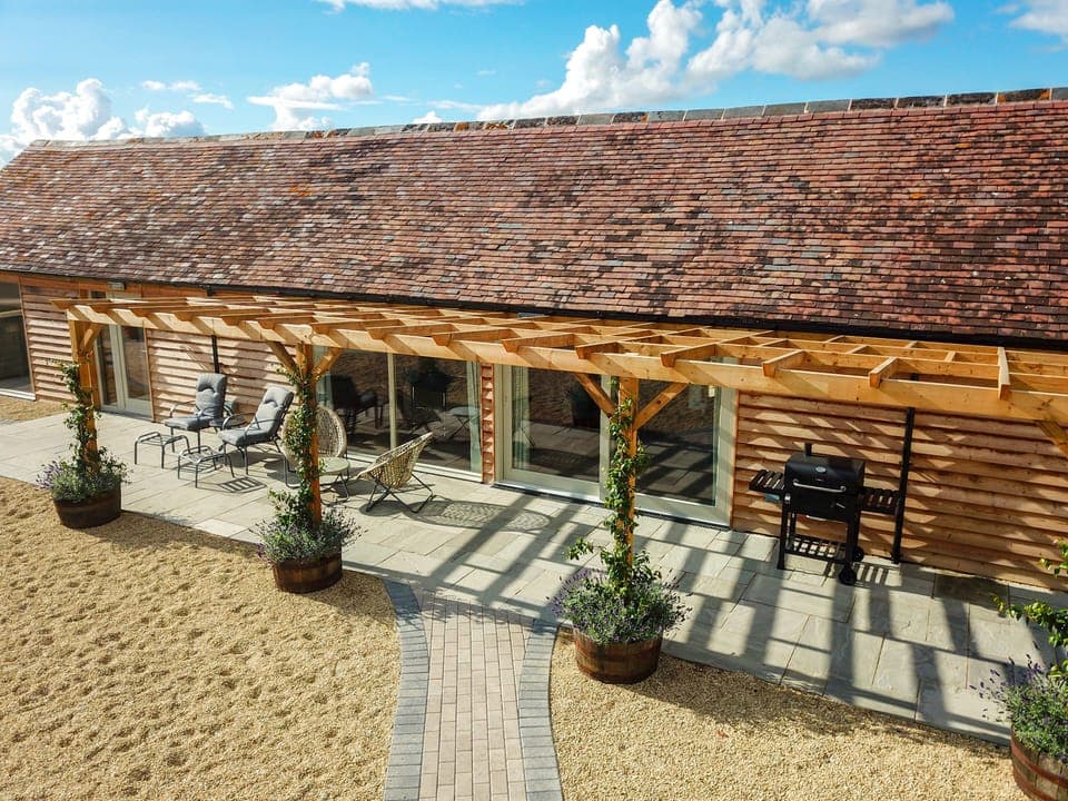 Large patio with sun loungers, picnic bench and BBQ