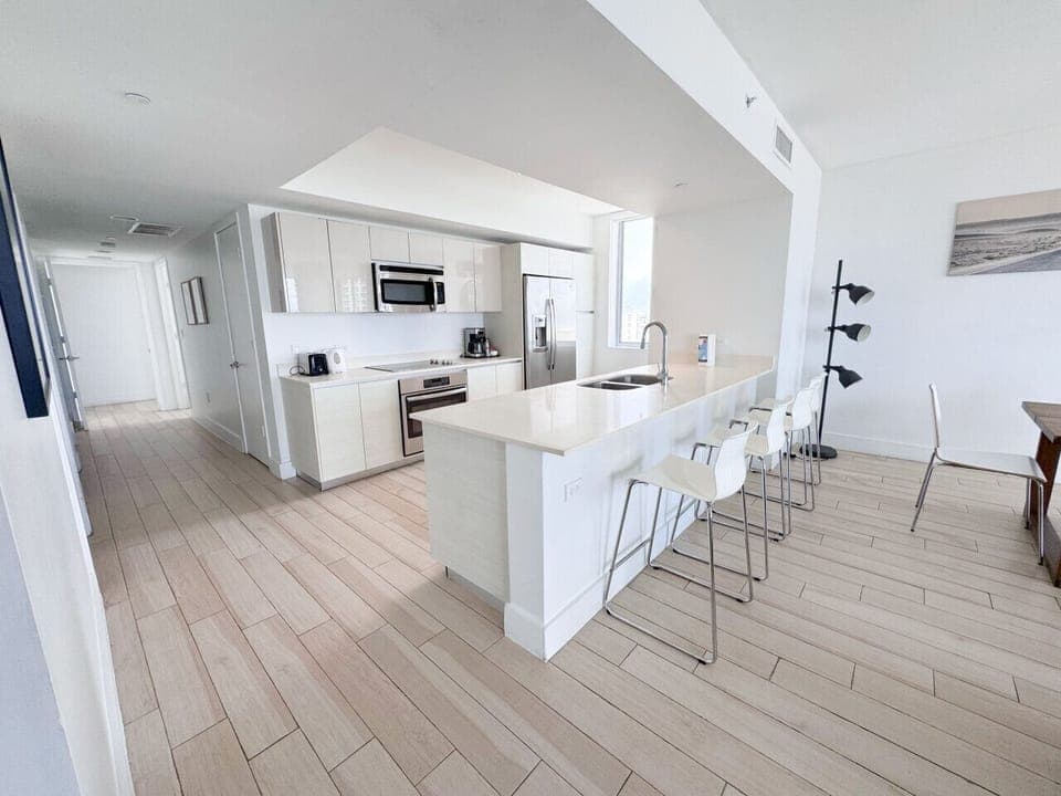 Fully equipped kitchen with stainless steel appliances and a stylish backsplash.