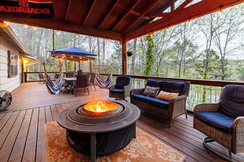Spacious deck with fire pit, hammock chairs, and peaceful lake views.