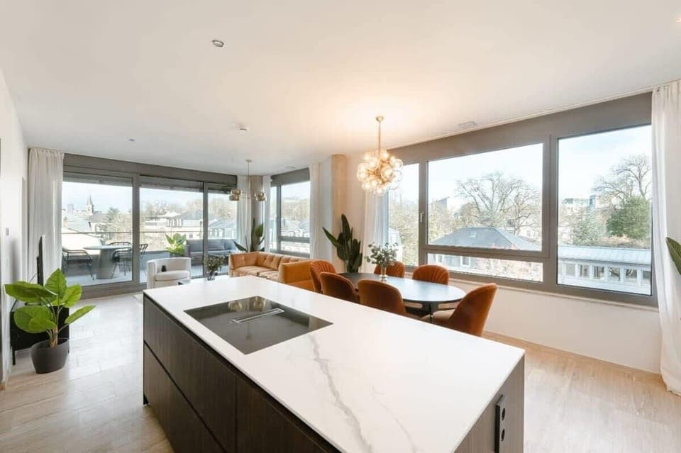 Spacious open-plan kitchen and dining area with large windows offering natural light and sweeping city views