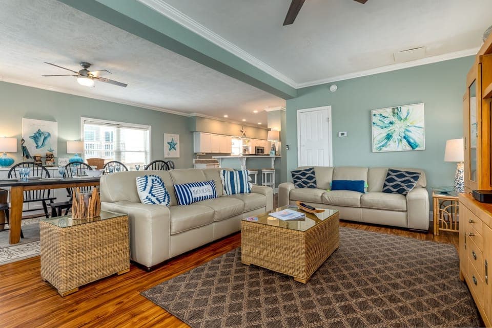 Sink into plush sofas in your coastal-inspired living space, where nautical blues meet warm wood tones for perfect relaxation.