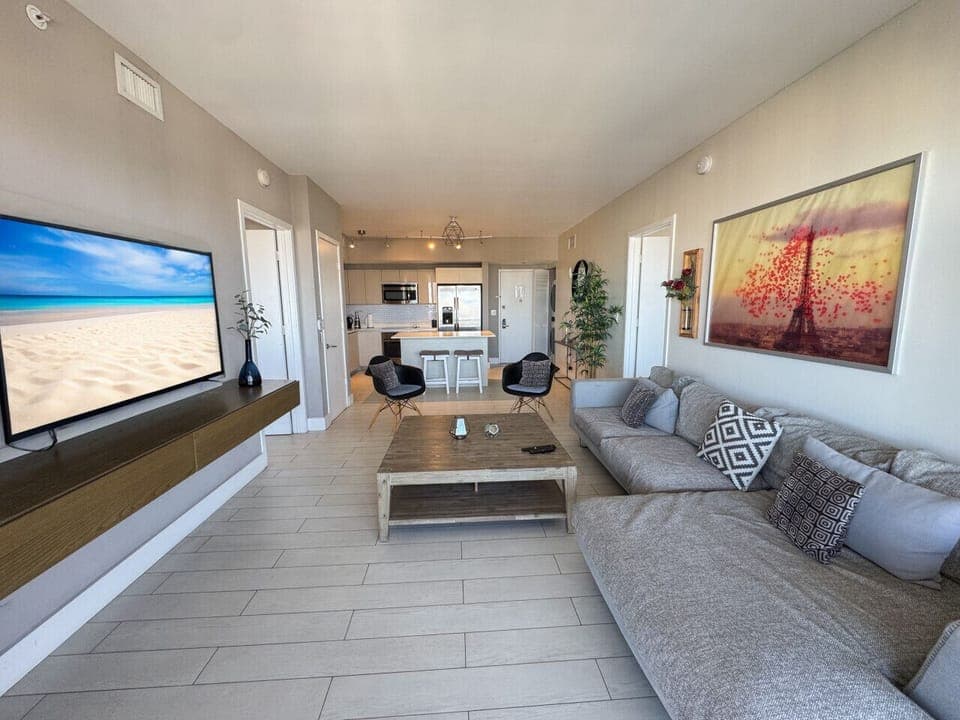 Bright living room with balcony access and city views.