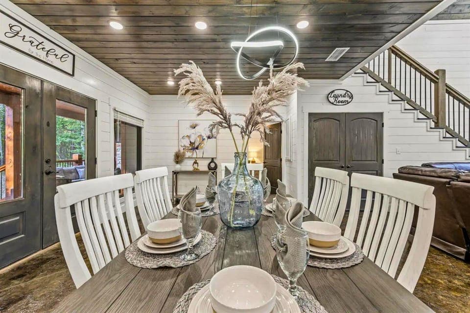 A beautifully set table under a rustic chic chandelier, creating an inviting mealtime environment.