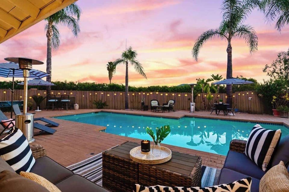 Your resort-style oasis sits on approximately 1-acre property and boasts a stunning swimming pool with a deep end of 9-1/2 feet and a shallow end around 4-1/2 to 5 feet. String lights, palm trees, and ample seating add a festive yet tranquil ambiance