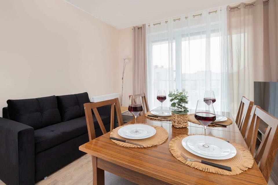 A closer look at a wooden dining table, set with plates, wine glasses, and decorative elements.