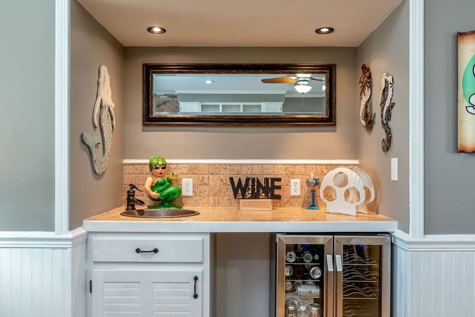 Your stylish wet bar awaits with wine storage and charming coastal decor, perfect for unwinding after beach days.