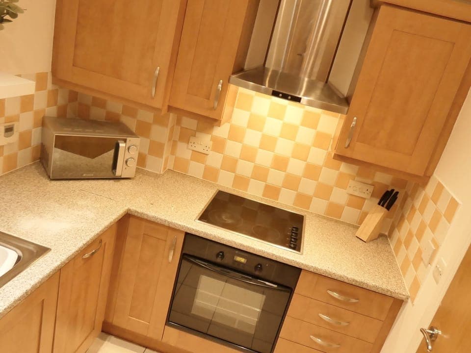 In the kitchen, a countertop holds two essential appliances, a toaster, and an electric kettle. 