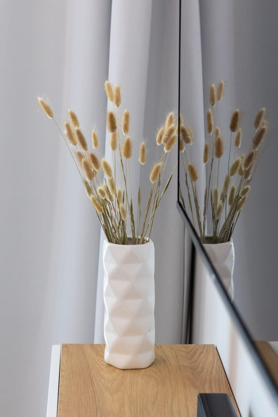 A simple vase with dried reeds, adding a natural decorative element to the bright interior.





