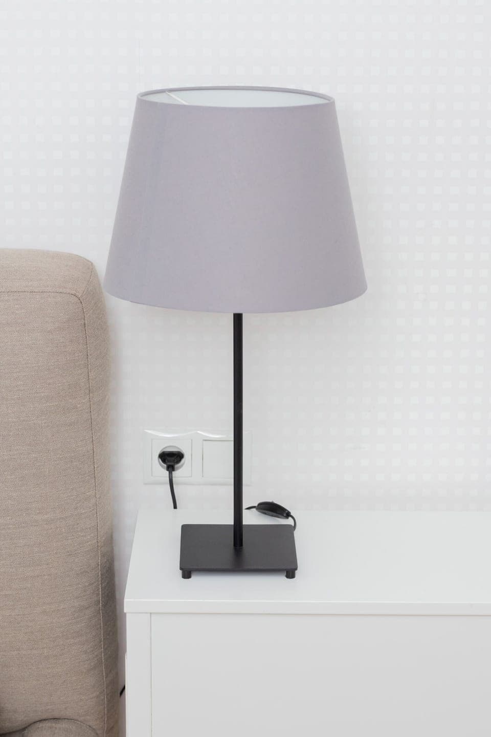 A close-up of a bedside lamp on a nightstand, adding a stylish and functional accent to the bedroom.
