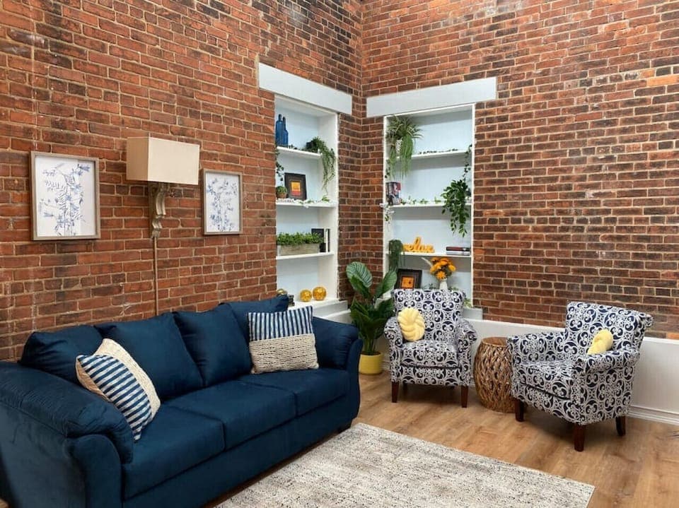 Living space with 16+ foot ceiling and skylights. Original brick from when the hotel was built in 1893.