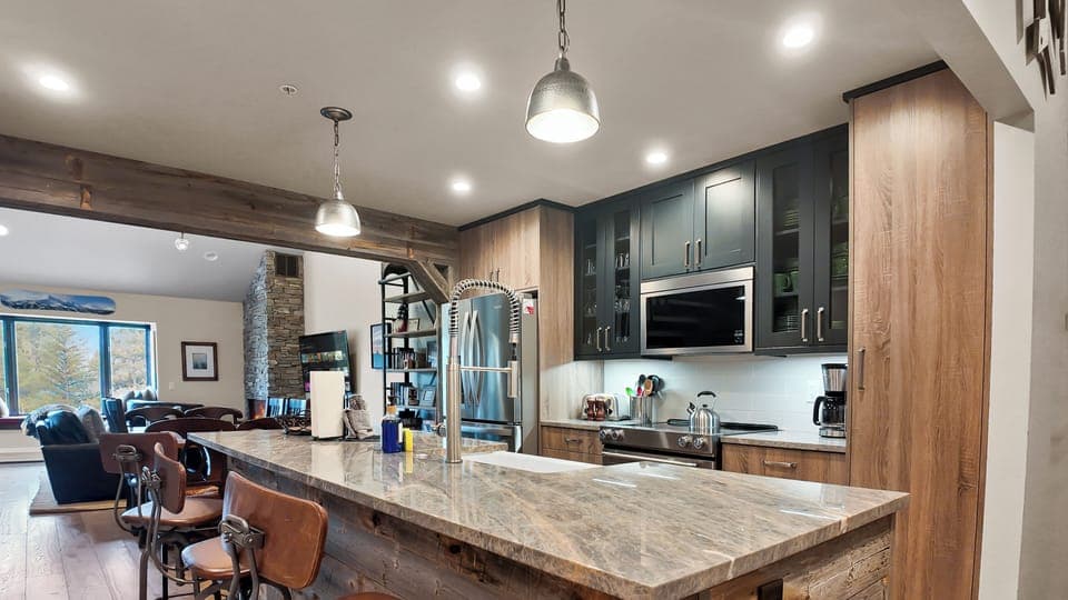 Spacious kitchen island with pendant lights, ideal for group meals.