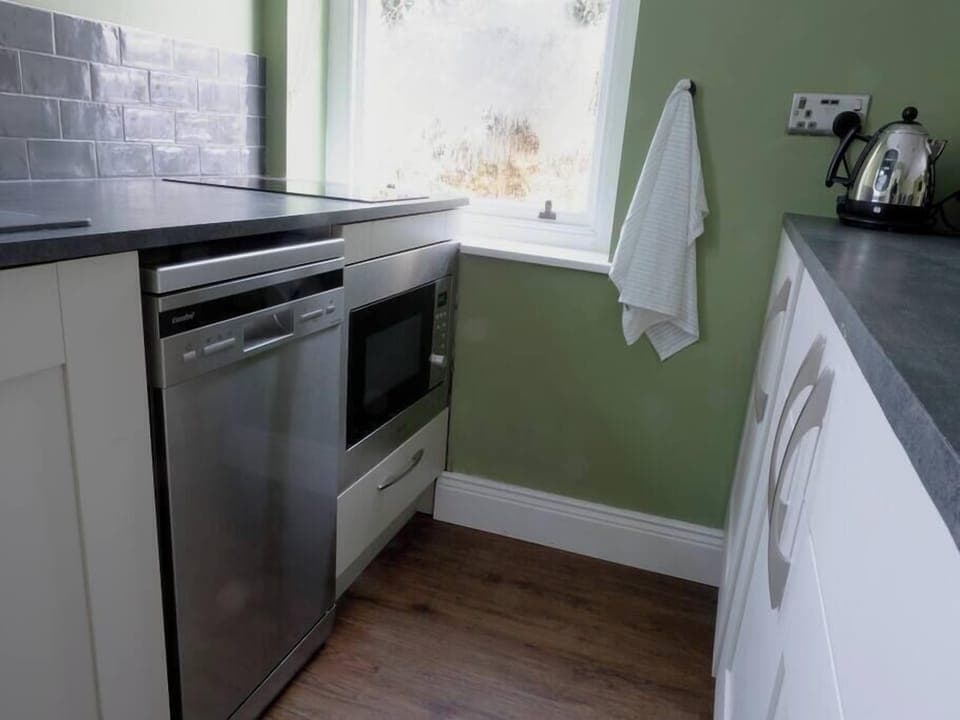 Galley kitchen area with convection oven / microwave, dishwasher and fridge.